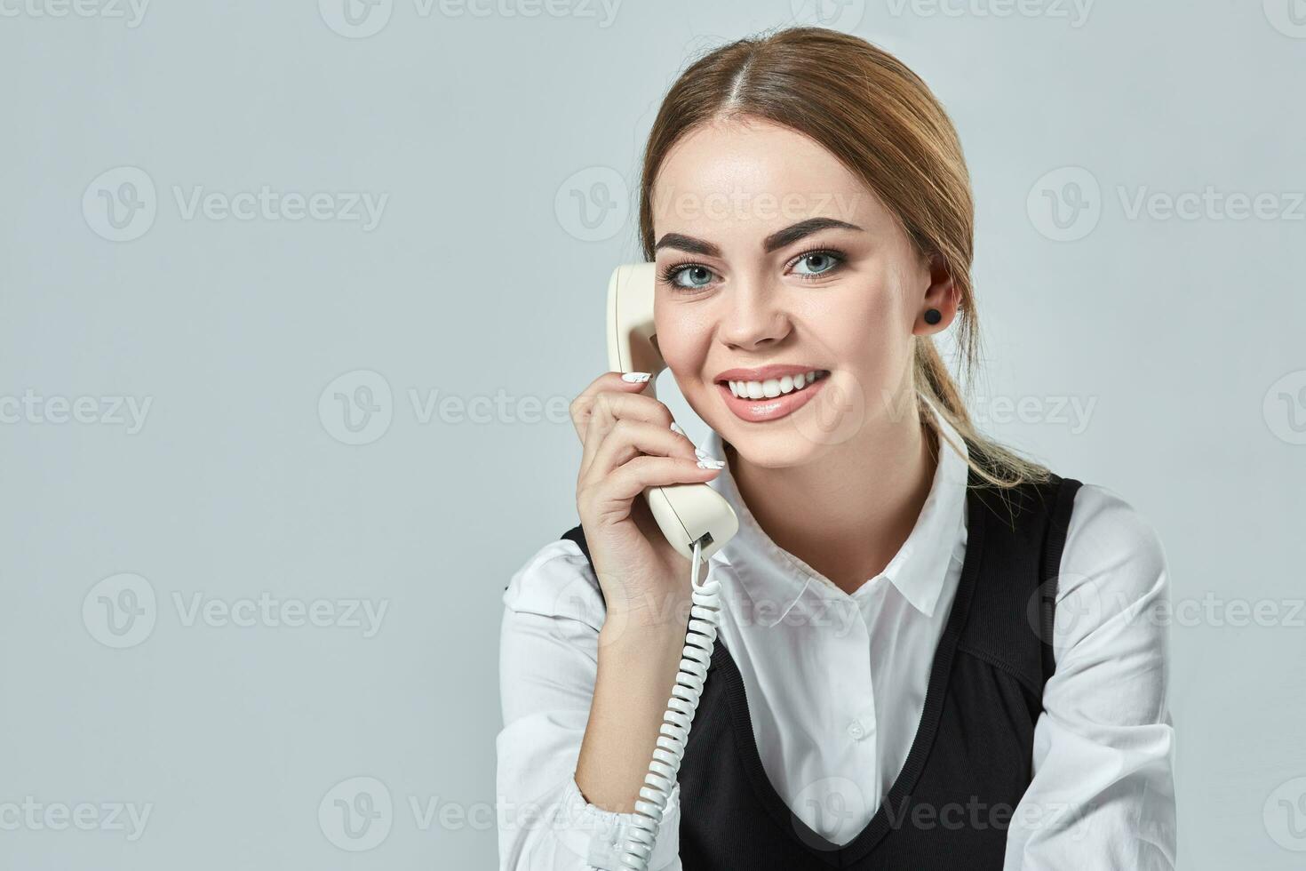 portrait of young secretary answering telephone photo