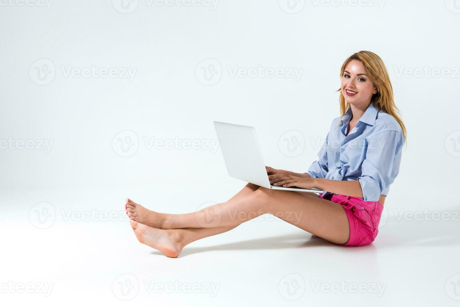 young woman sitting on the floor and using laptop photo