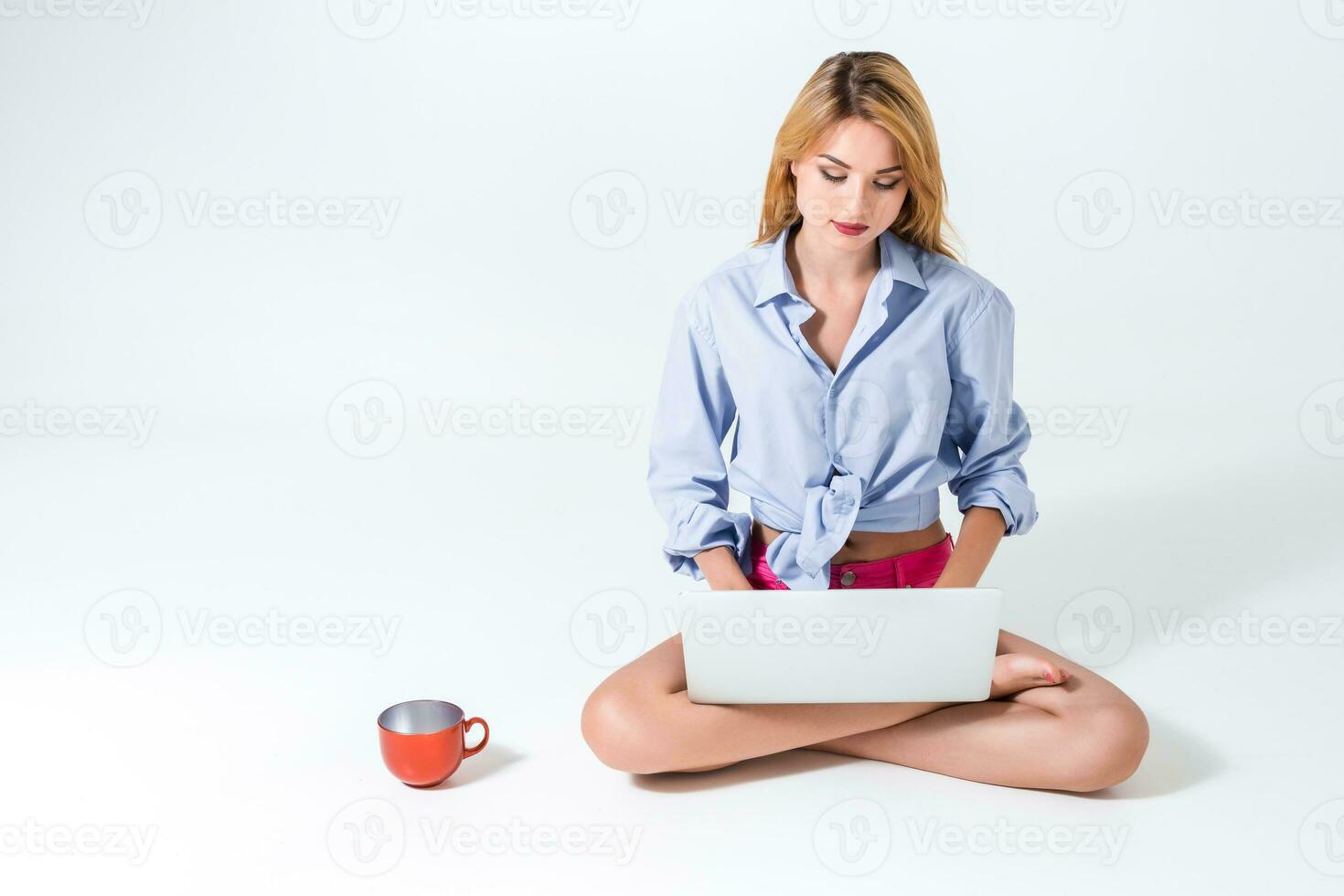 young woman sitting on the floor and using laptop photo
