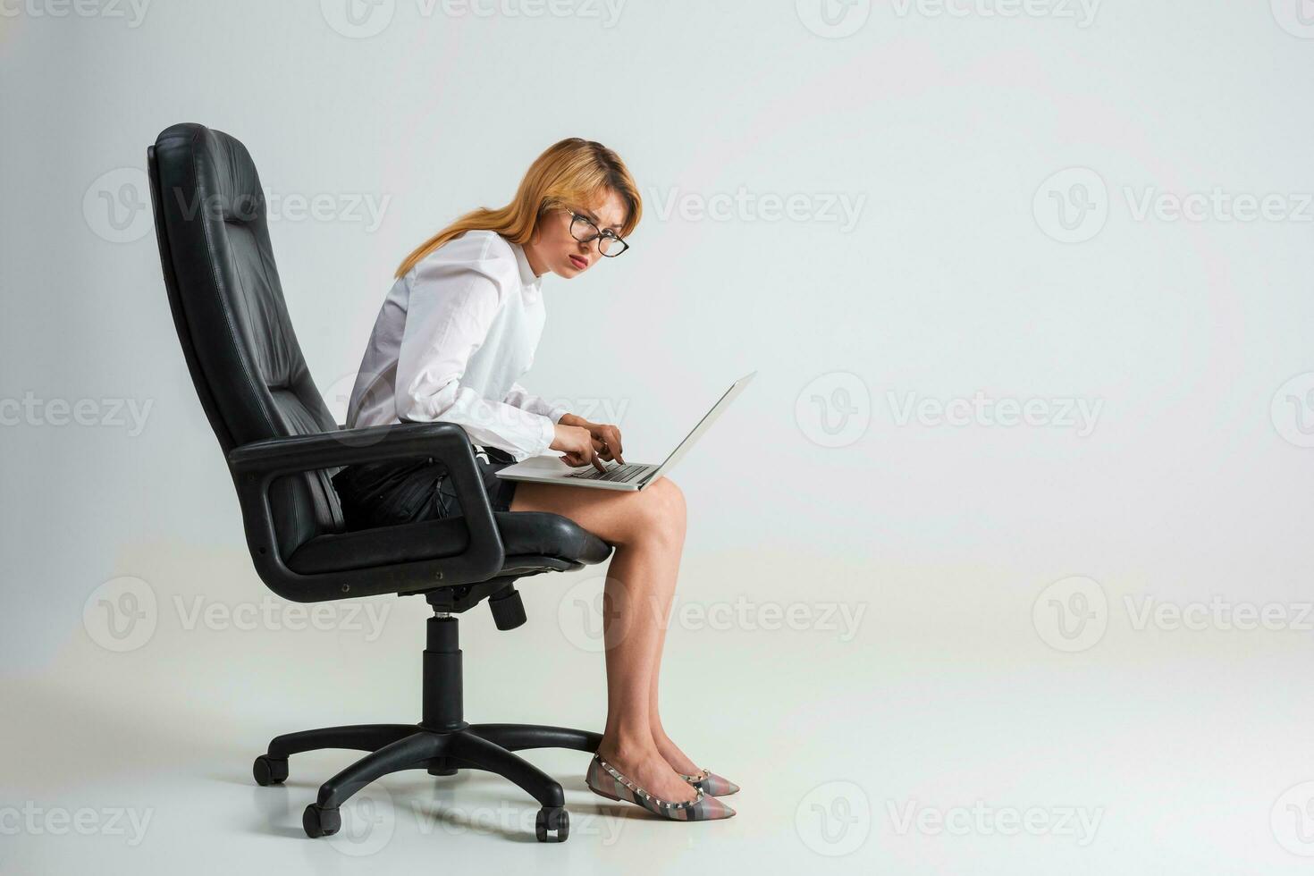 young woman sitting on the chair and using laptop photo