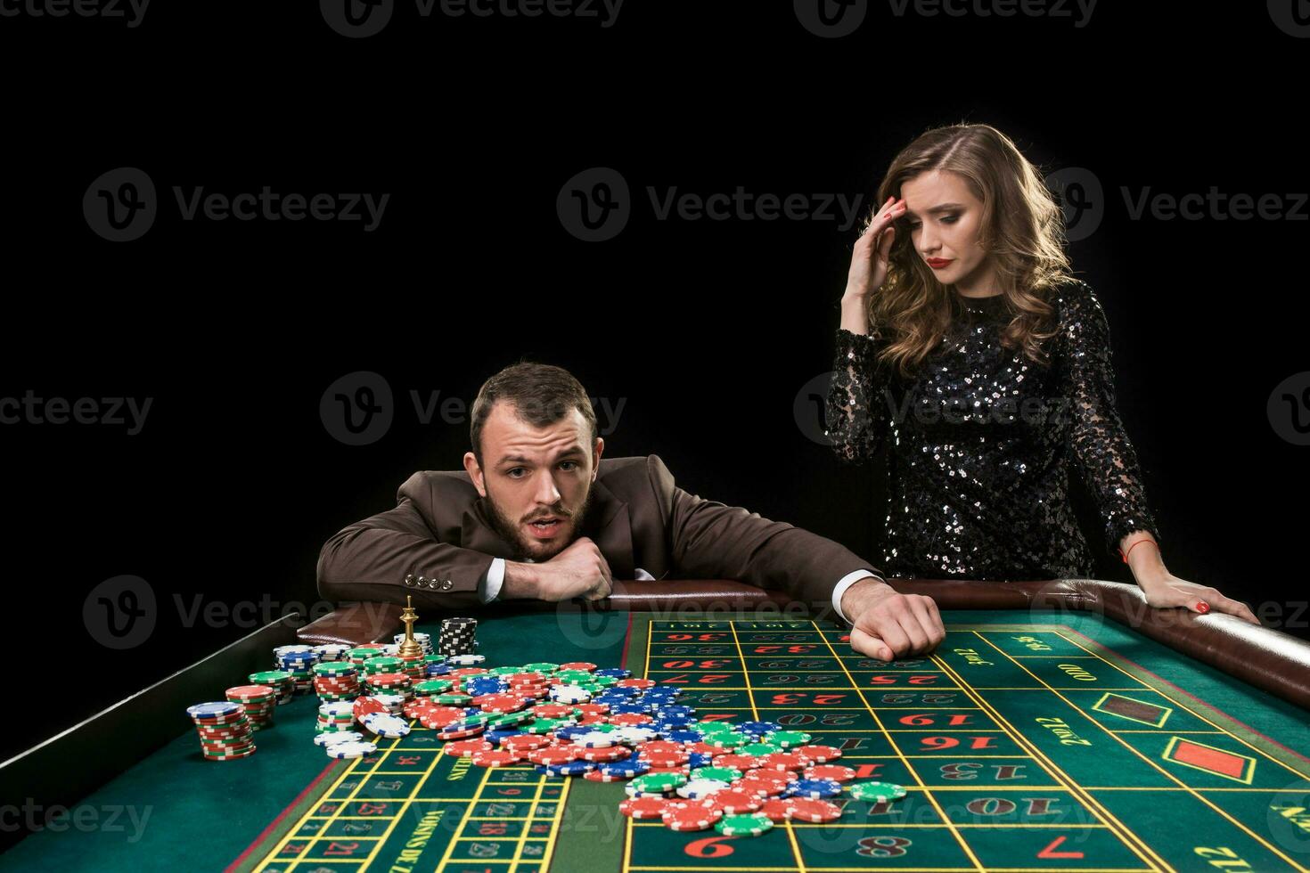 Man and woman playing at roulette table in casino photo