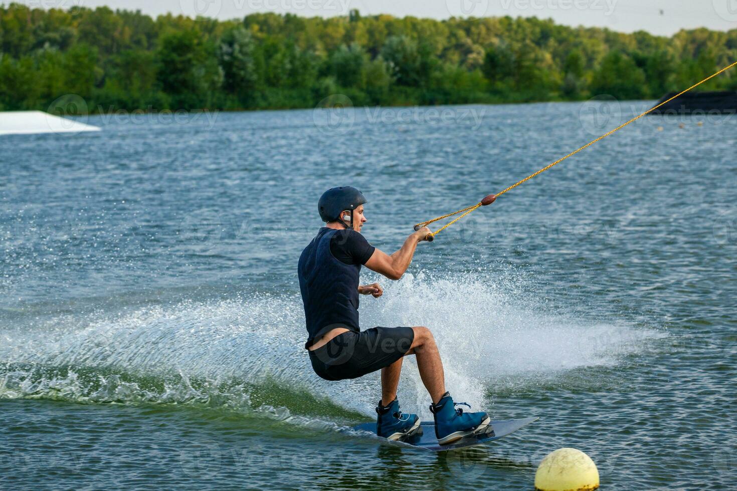 Experienced wakeboarder demonstrating freeride skills maneuvering between buoys photo