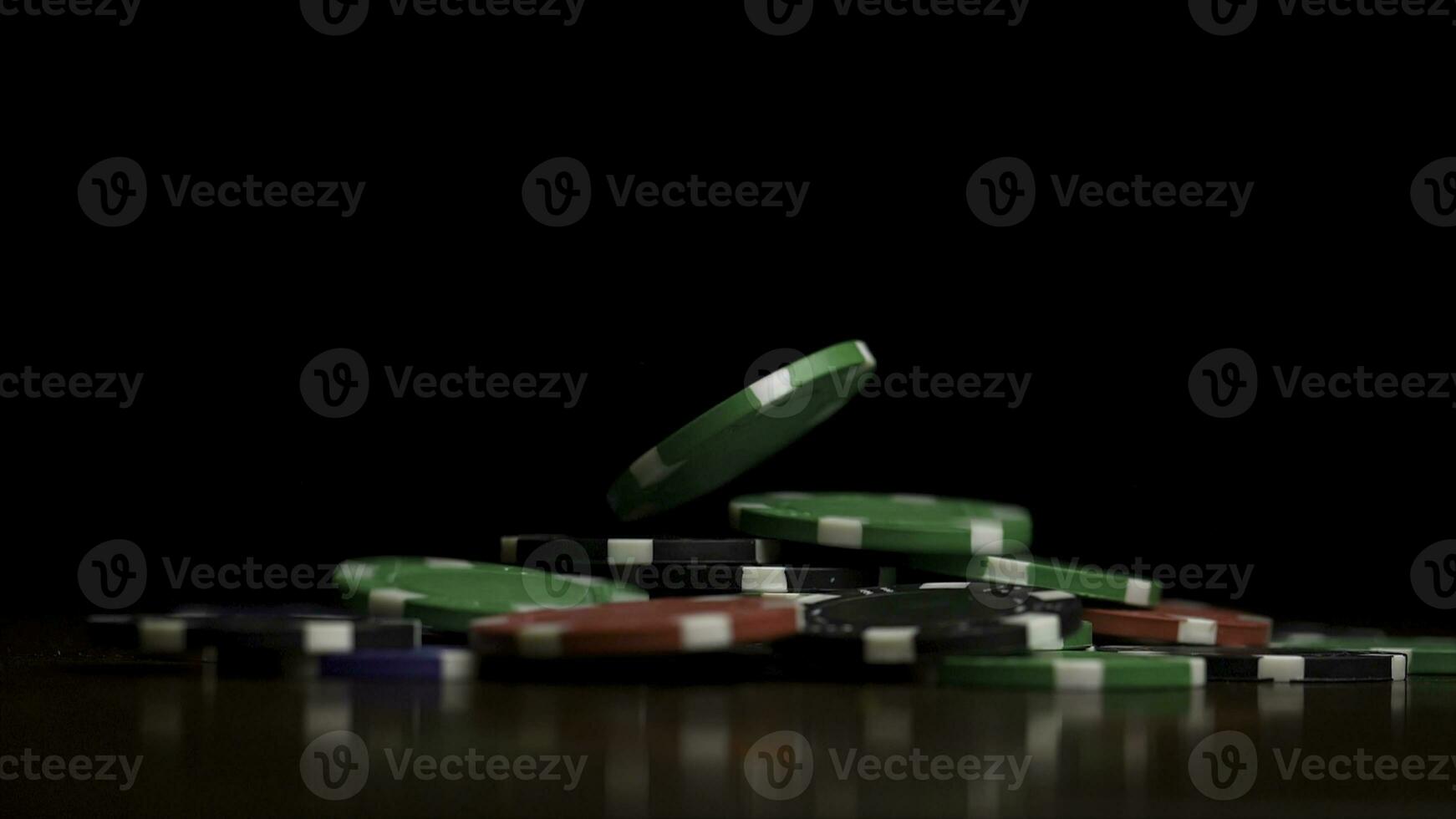 Falling poker chips isolated on black background. Falling poker chips isolated on black background. Colorful poker chips falling at the table on black background. Playing chips flying at the black photo