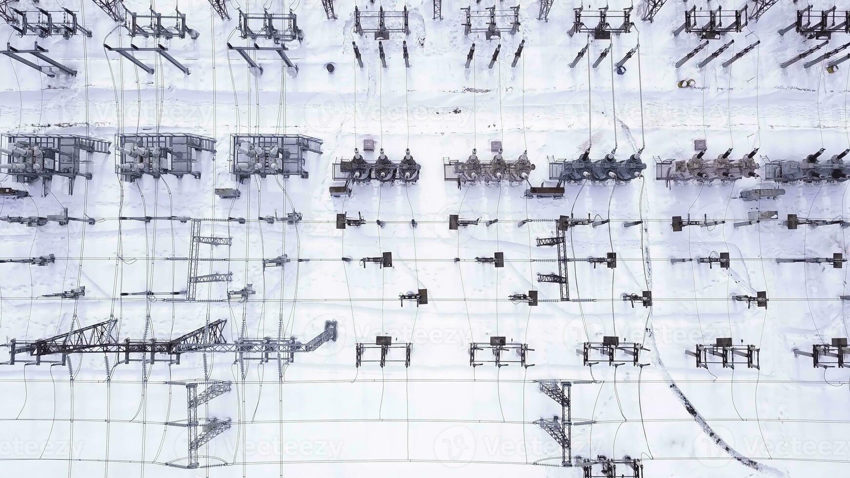 Rows of electric poles. Action. Top view of electrical substation with rows of transformers in winter. Powerful electrical substation with new equipment in winter. Electric power industry photo