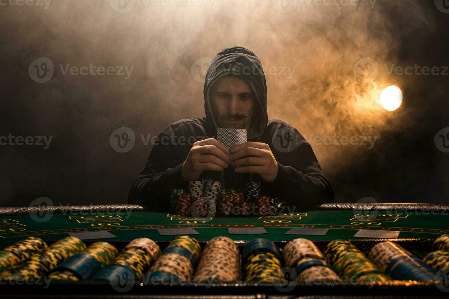 Portrait of a professional poker player sitting at pokers table photo