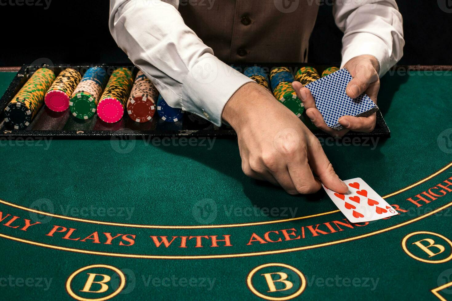 Close up of holdem dealer with playing cards and chips on green table photo