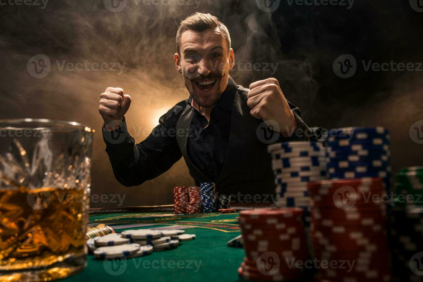 Young handsome man sitting behind poker table with cards and chips photo