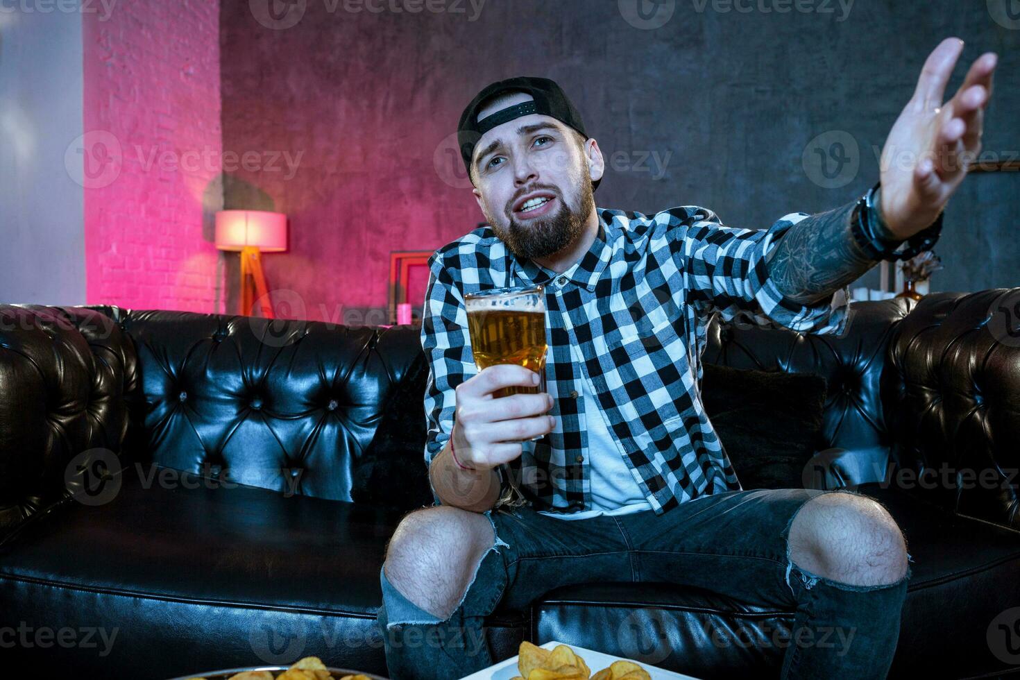 Young fanatic man watching football game on television nervous a photo