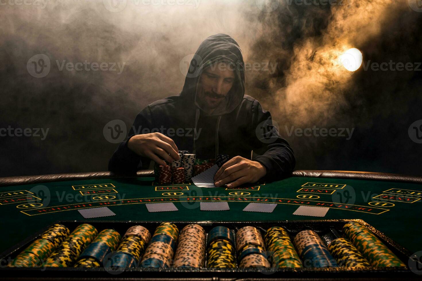 Portrait of a professional poker player sitting at pokers table photo