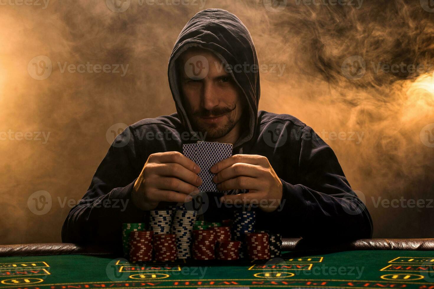 Portrait of a professional poker player sitting at poker table photo
