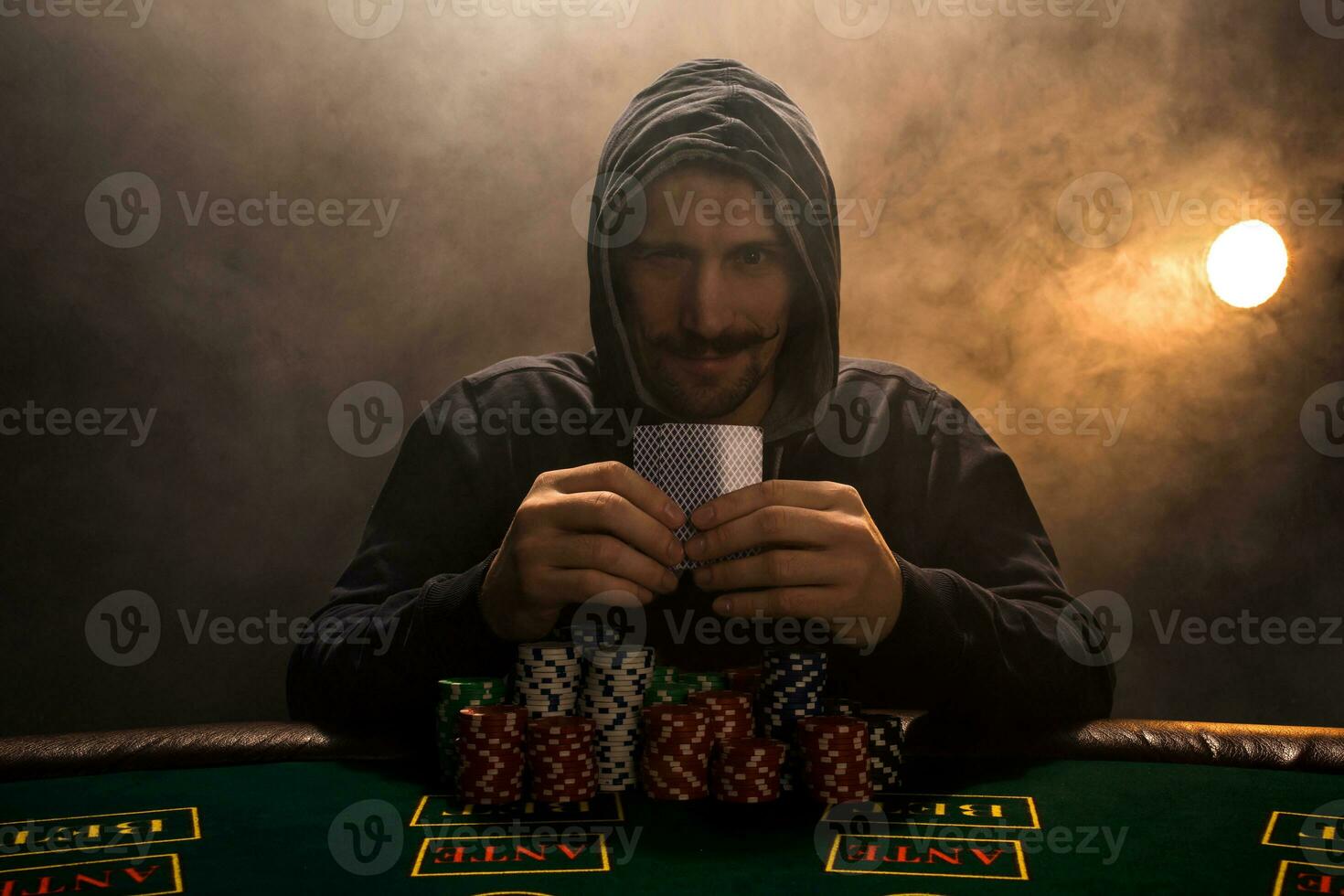 hombre es jugando póker con un cigarro y un whisky. un hombre victorioso todas el papas fritas en el mesa con grueso cigarrillo fumar. foto