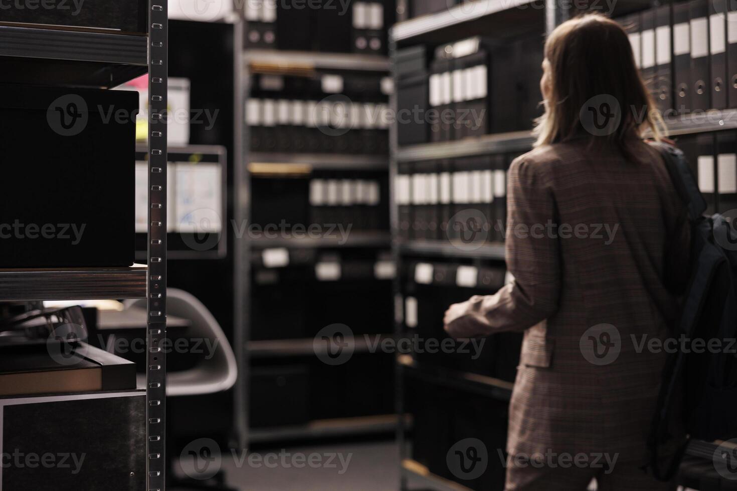 Selectiv focus of metallic storage full with administrative files, arhive room equipped with bureaucracy documents. Corporate employee working late at night searching for accountancy report photo