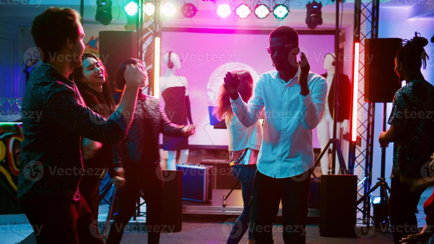 contento hombre bailando con personas a club, teniendo divertido en miedoso frio música a discoteca. joven persona ir de fiesta y saltando alrededor en danza piso, social reunión a bar. Mano disparo. foto