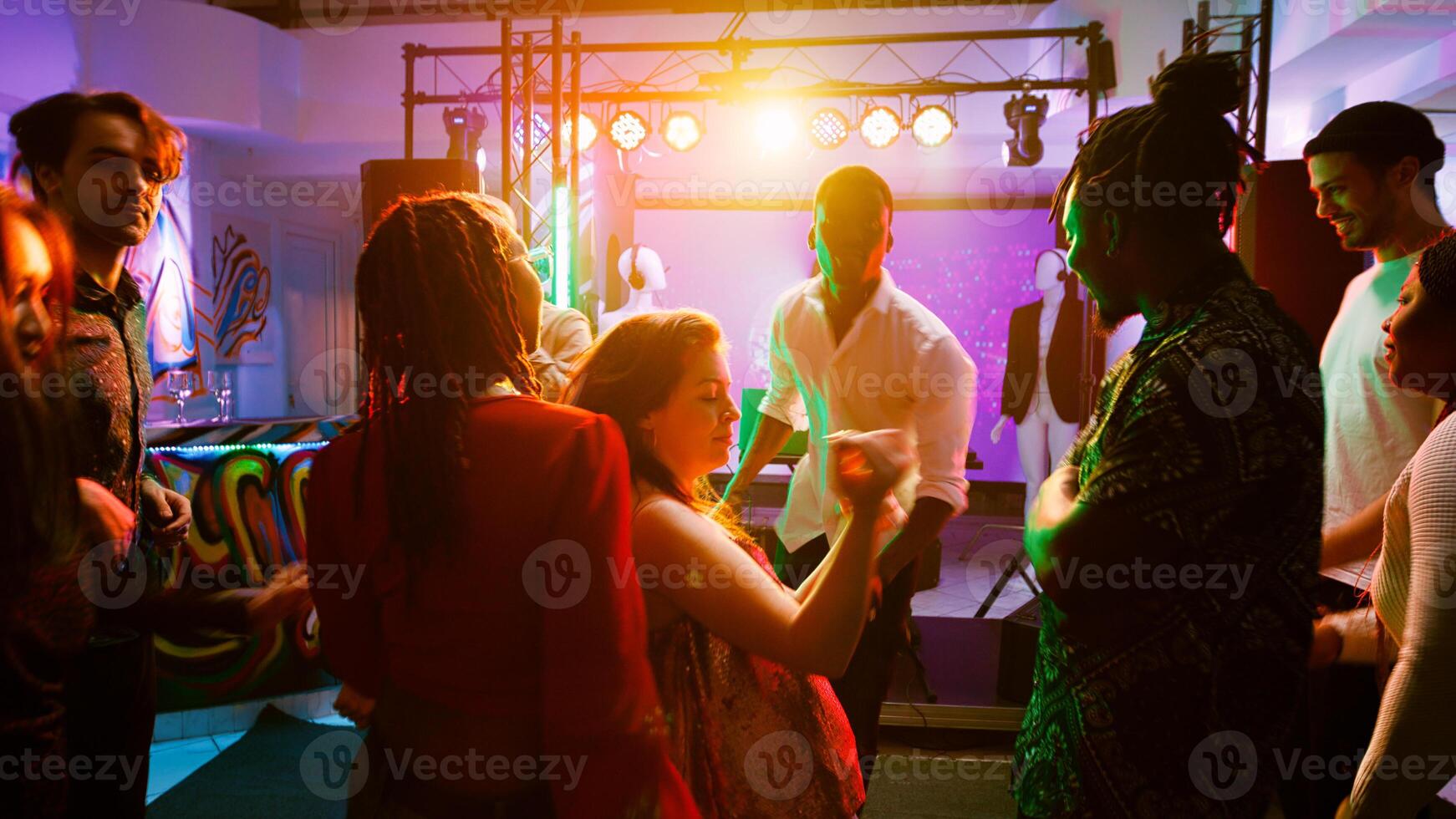 POV of funky people dancing around and feeling happy at club, enjoying modern party with disco lights and live show. Group of persons partying at nightclub, moving on dance floor. Handheld shot. photo