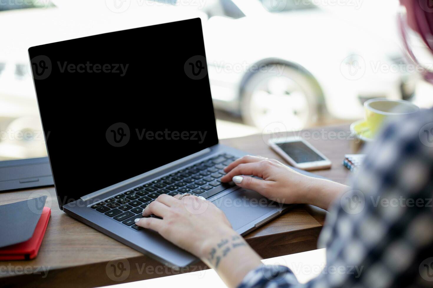 mujer mecanografía en cuaderno con blanco pantalla con Copiar espacio para tu texto o publicidad contenido, sentado a de madera mesa foto