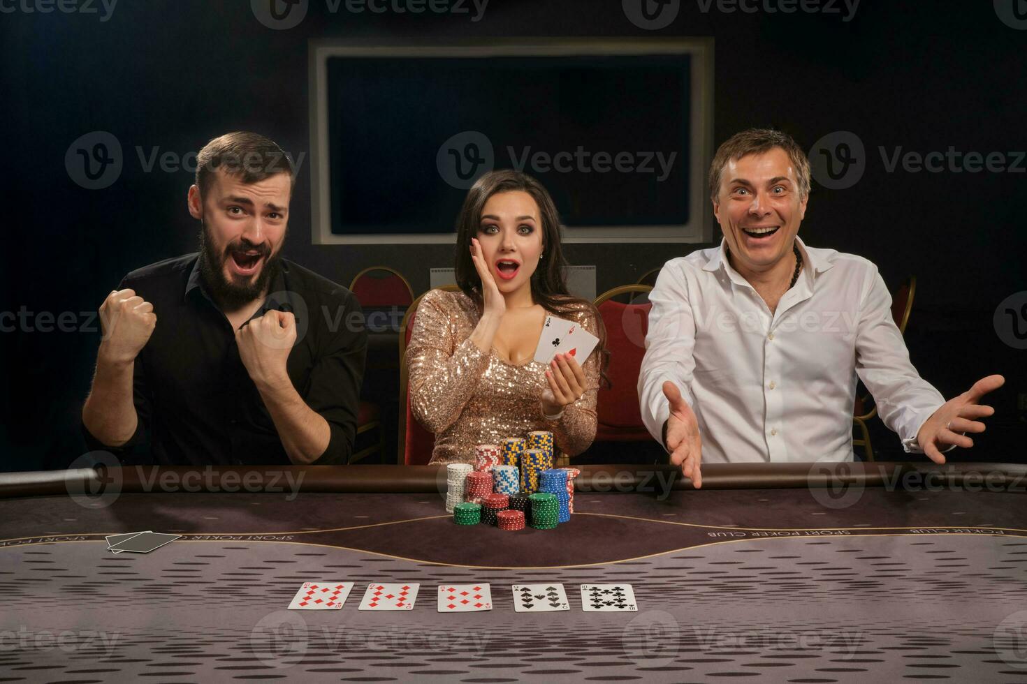 Group of a young rich friends are playing poker in casino. photo