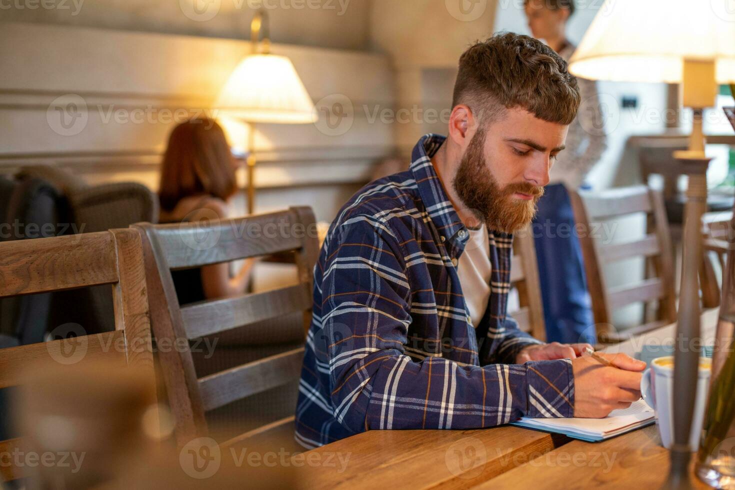 Casual business man or freelancer planning his work on notebook, working on laptop computer with smart phone, cup of coffee on table at coffee shop or home office. photo