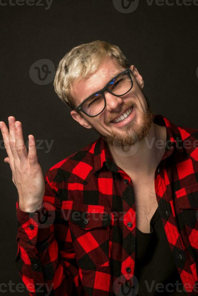 Man in red shirt in cage with glasses on black background photo