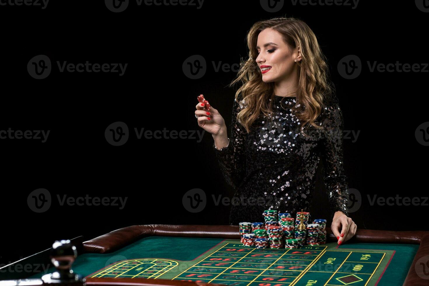 Woman playing in casino. Woman stakes piles of chips playing rou photo