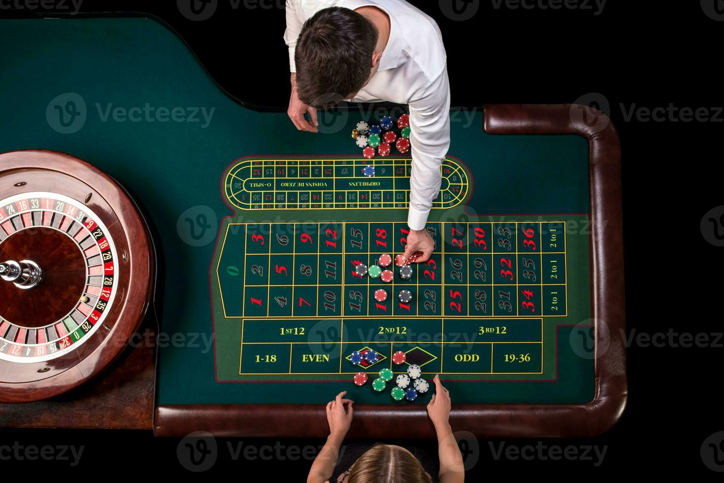 Man croupier and woman playing roulette at the table in the casino. Top view at a roulette green table with a tape measure. photo