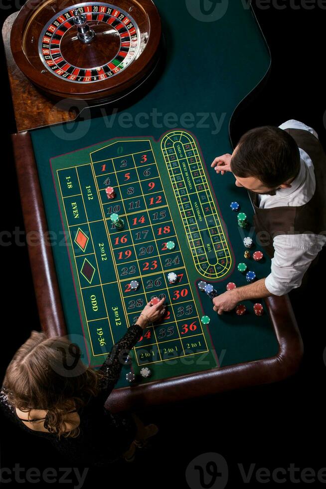 Croupier and woman player at a table in a casino. Picture of a c photo