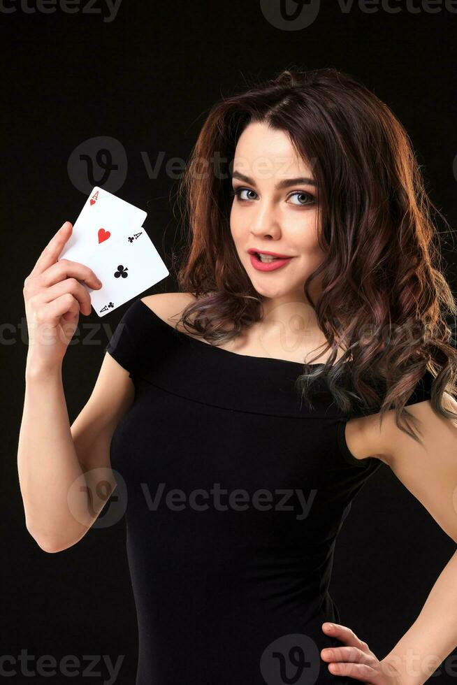 Young woman playing in the gambling on black background photo