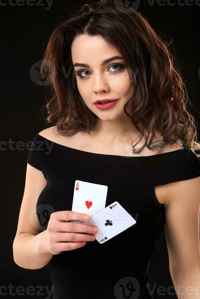 Young woman playing in the gambling on black background photo