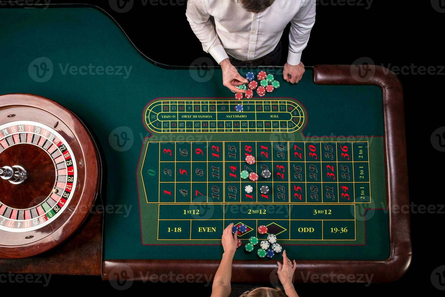 hombre crupier y mujer jugando ruleta a el mesa en el casino. parte superior ver a un ruleta verde mesa con un cinta medida. foto