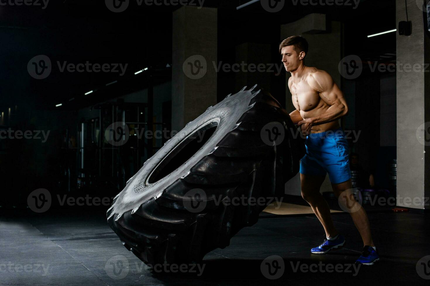 training - man flipping tire in gym photo