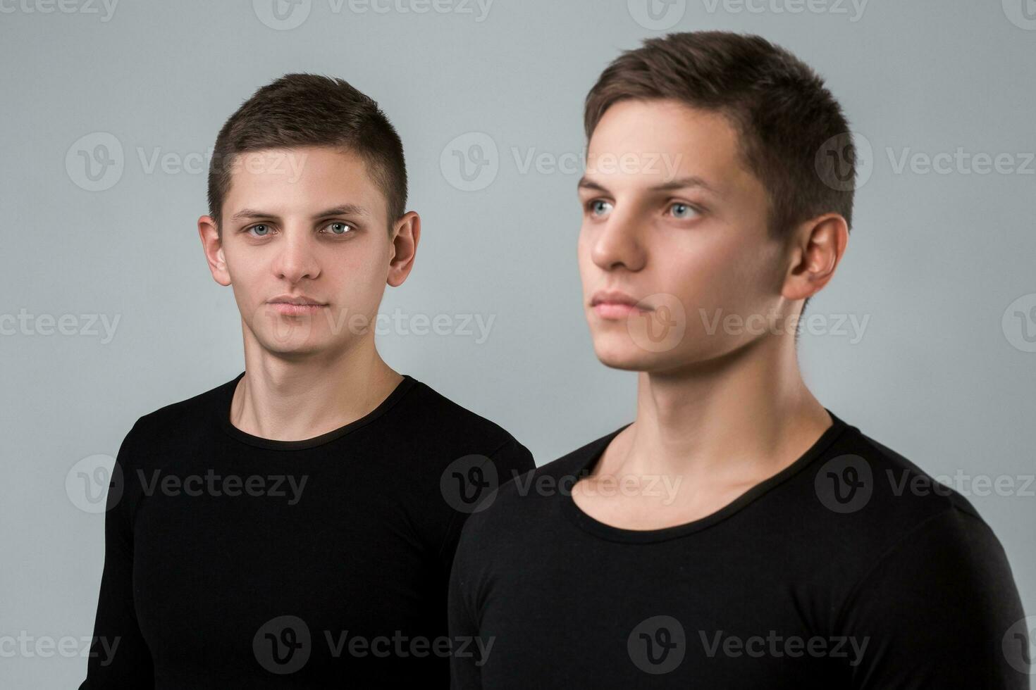 The two twin brother stand on the gray background photo