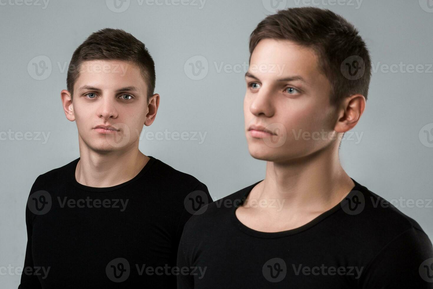 The two twin brother stand on the gray background photo