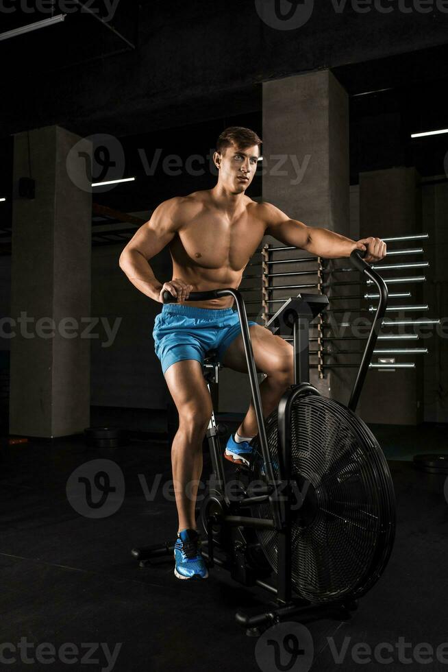 atleta hombre andar en bicicleta en el gimnasia. foto