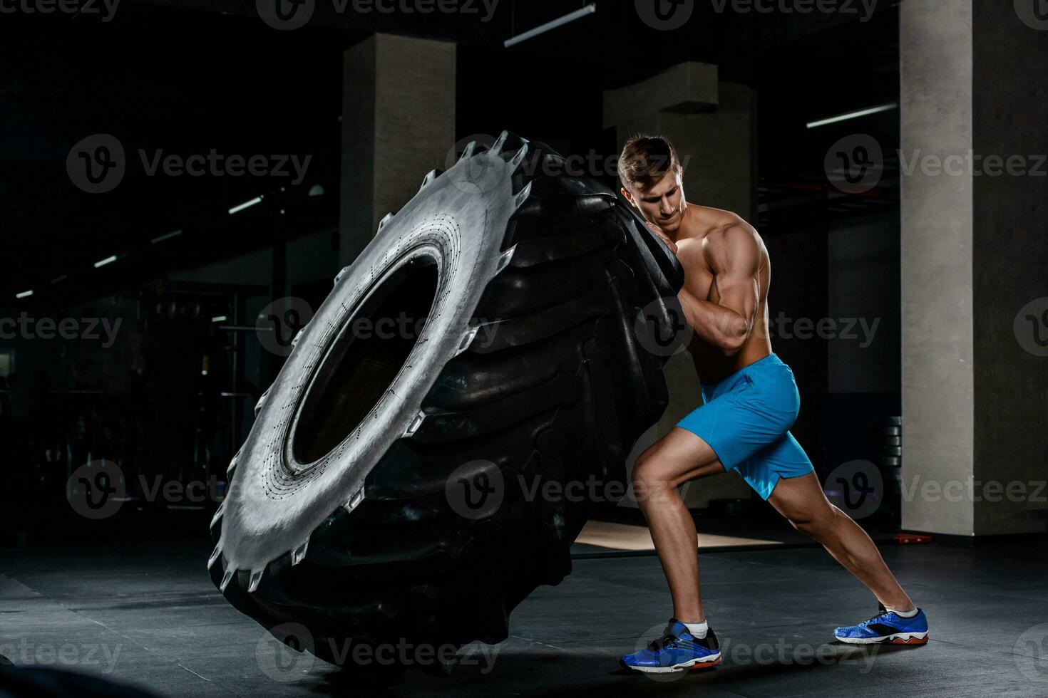crossfit formación - hombre voltear neumático en gimnasio foto
