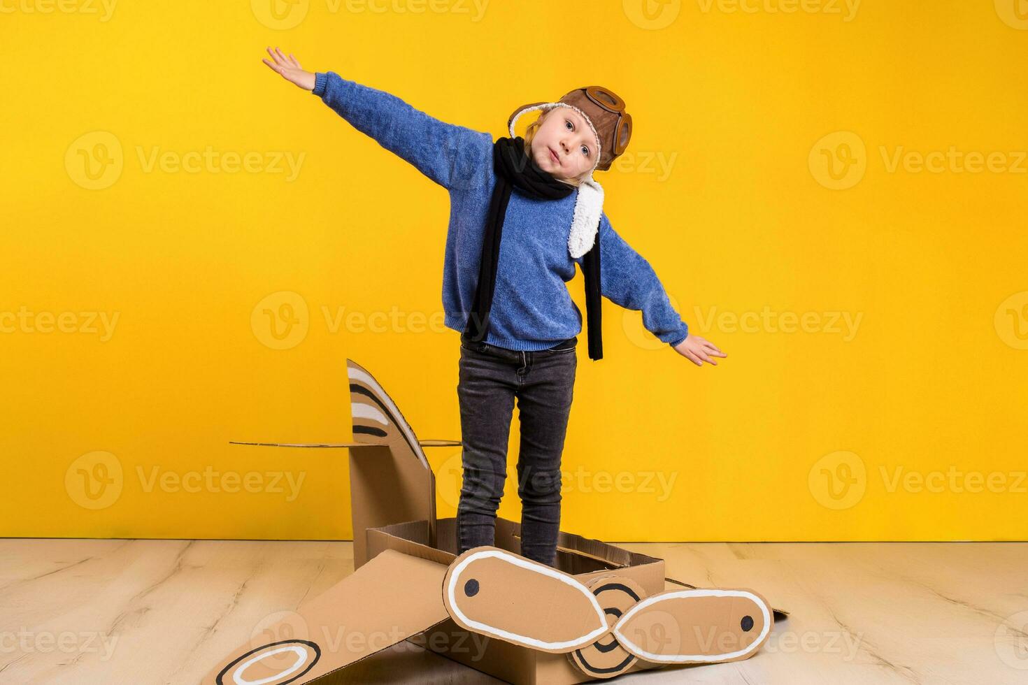 Little dreamer girl playing with a cardboard airplane. Childhood. Fantasy, imagination. photo