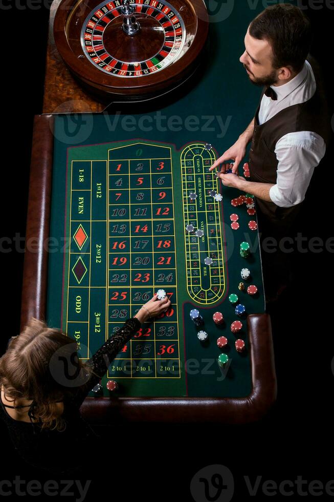 Croupier and woman player at a table in a casino. Picture of a c photo