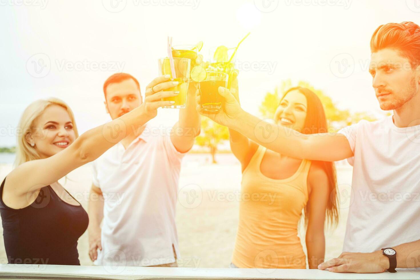 Friends having fun at the bar outdoors, drinking cocktails. photo