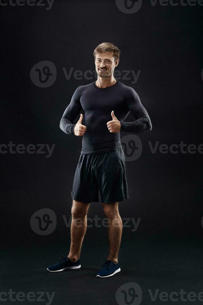 Male model in active sportswear against black background with copy space photo