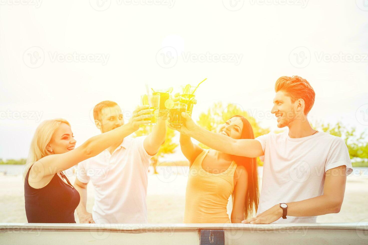 Friends having fun at the bar outdoors, drinking cocktails. photo