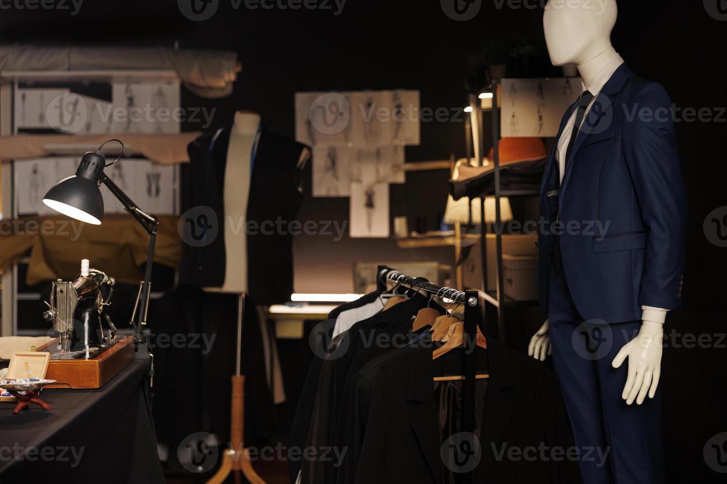 Exquisite professional tailoring studio full of premium quality bespoken sartorial collection and fashion design sketch drawings on walls. Atelier shop with stylish elegant clothing on mannequins photo