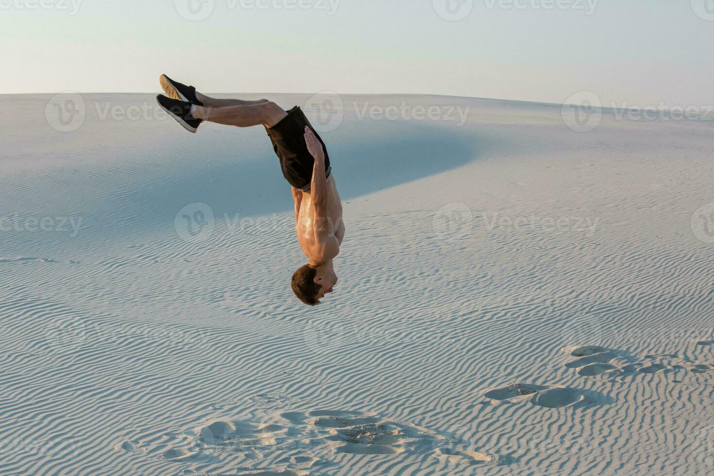 Man study parkour on their own. Acrobatics in the sand photo