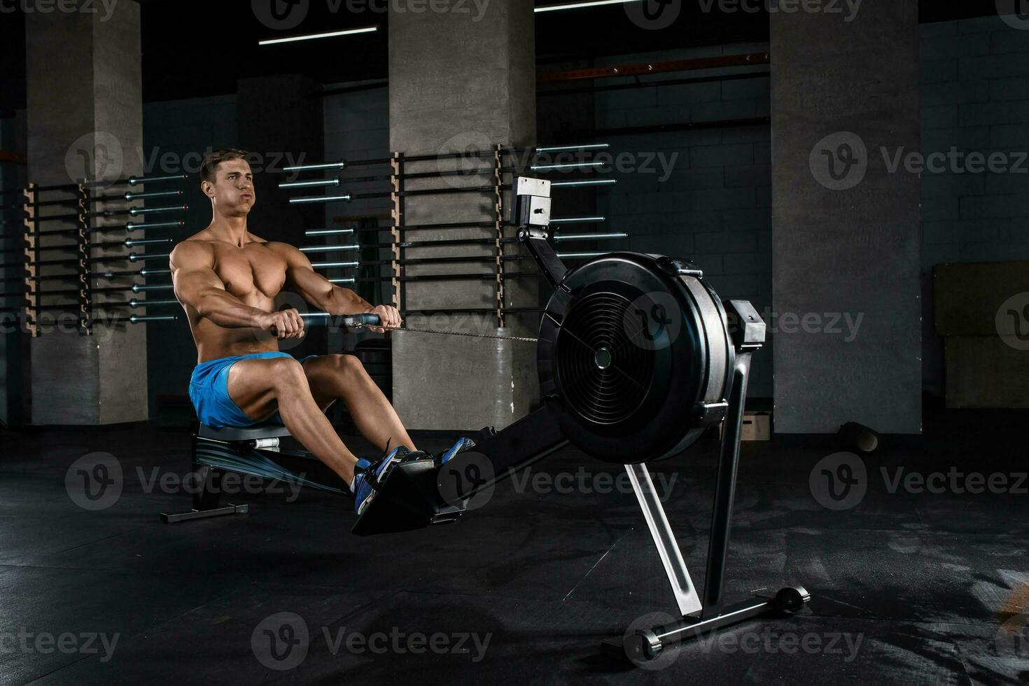 Bodybuilder working on his legs with weight machine at the gym photo