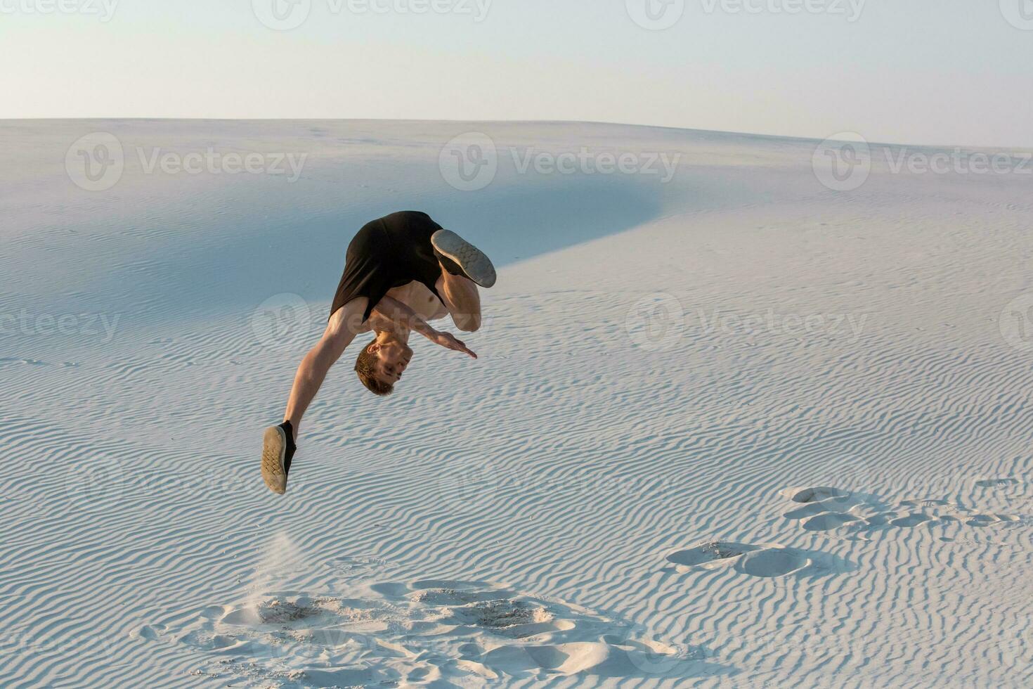 Man study parkour on their own. Acrobatics in the sand photo