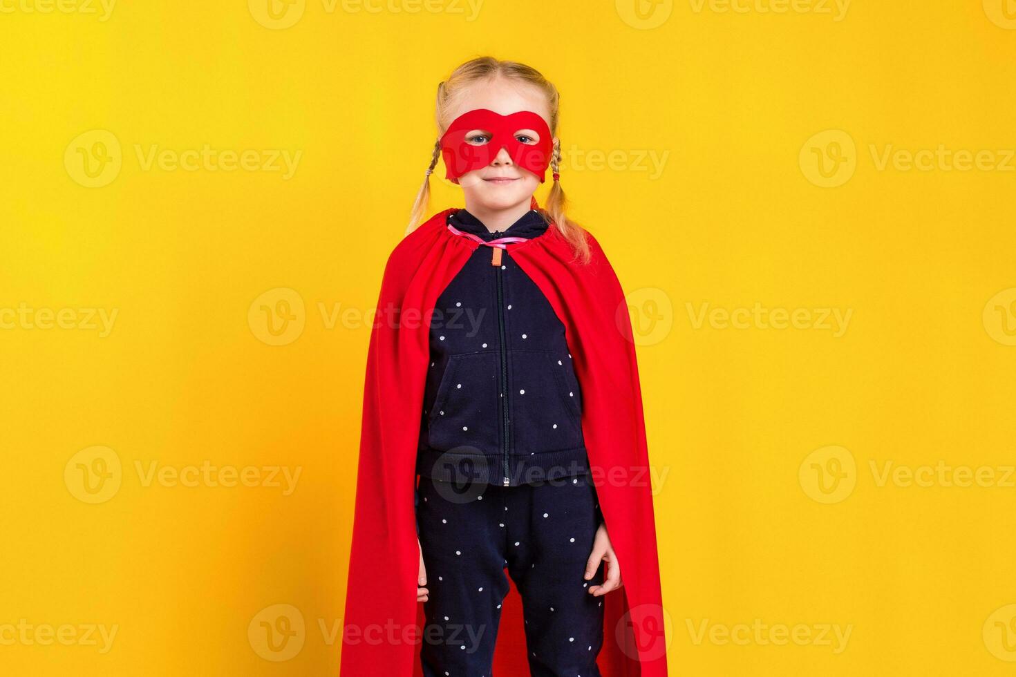 Superhero little girl in a red raincoat and a mask photo