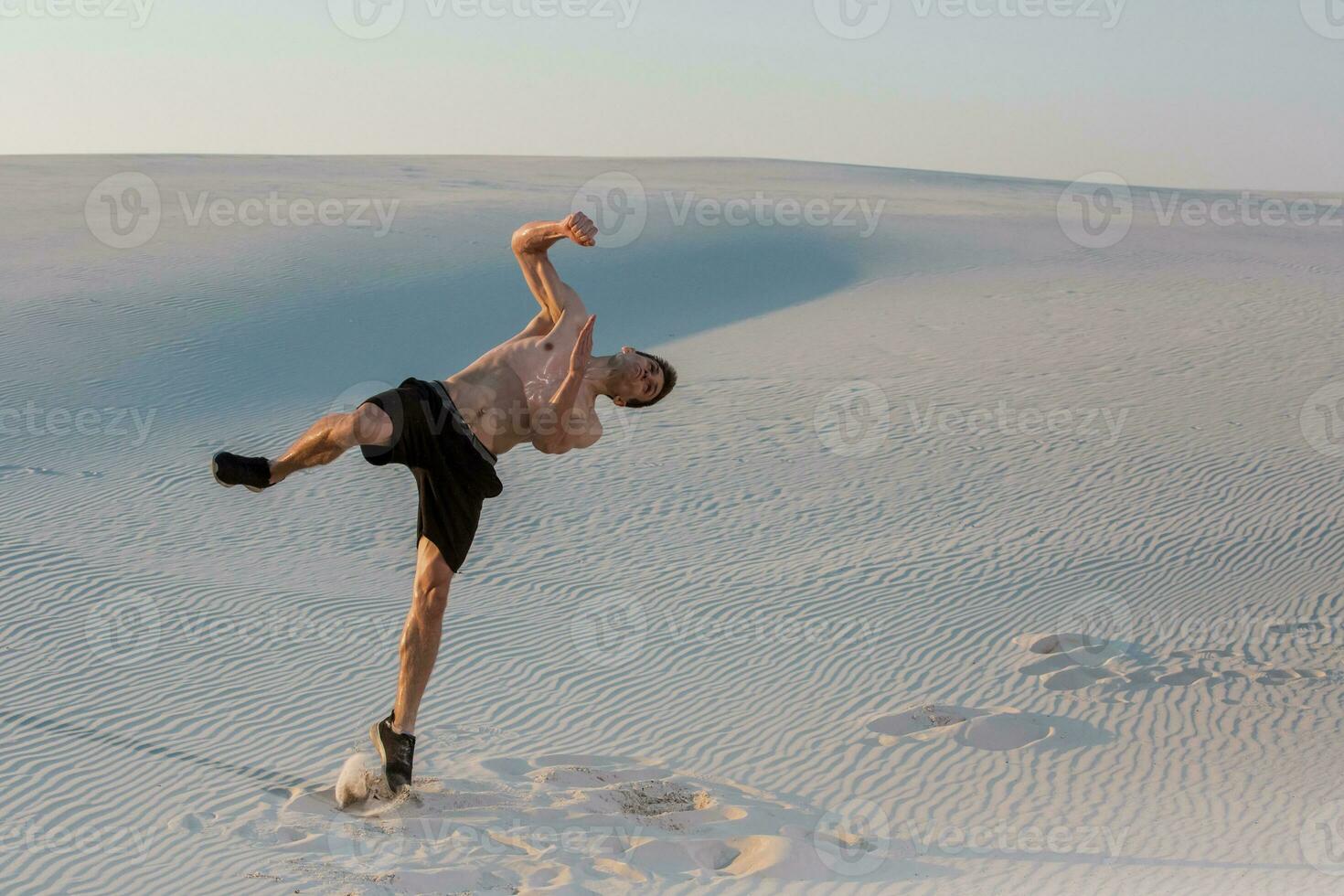 Man study parkour on their own. Acrobatics in the sand photo