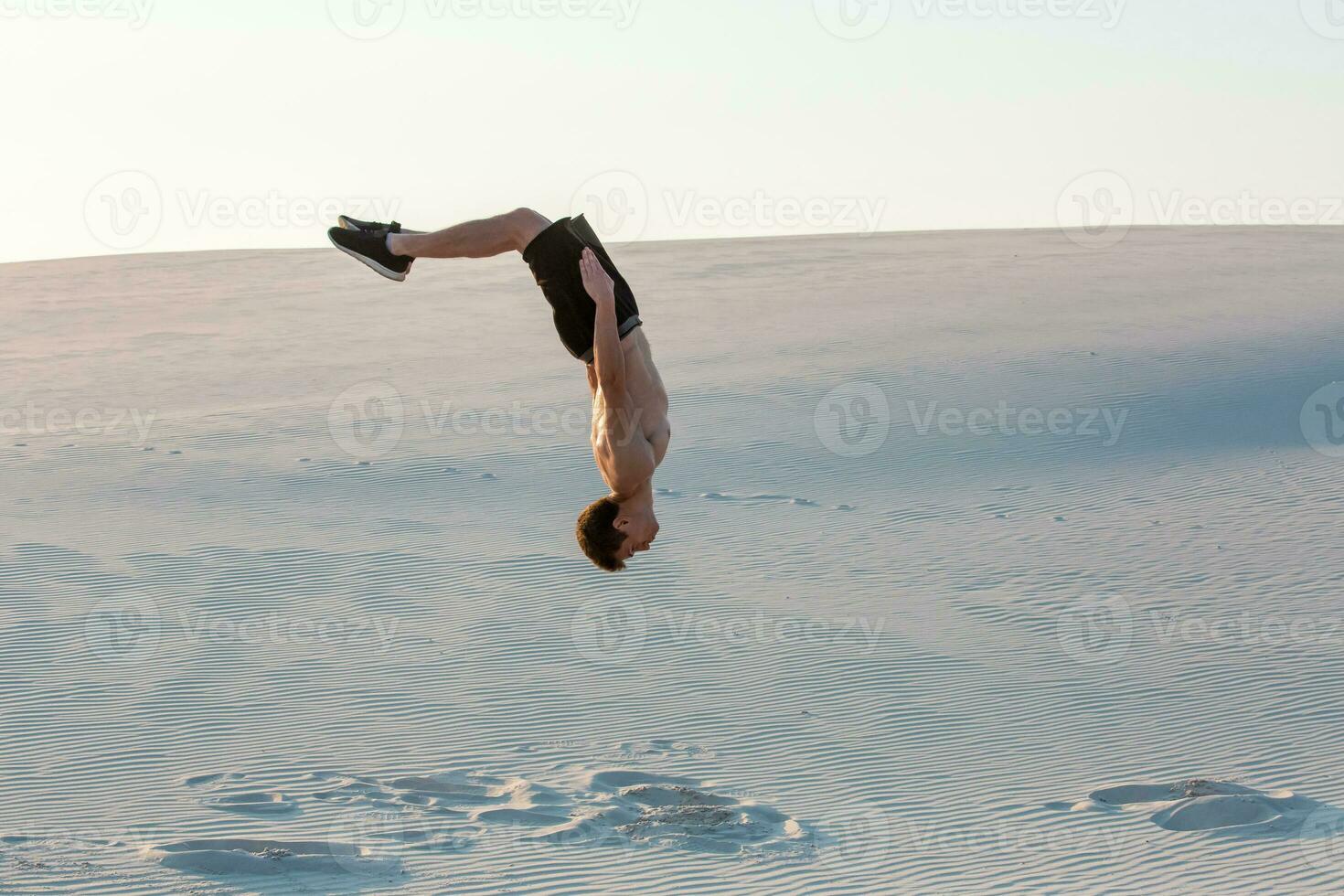 hombre estudiar parkour en su propio. acrobacia en el arena foto