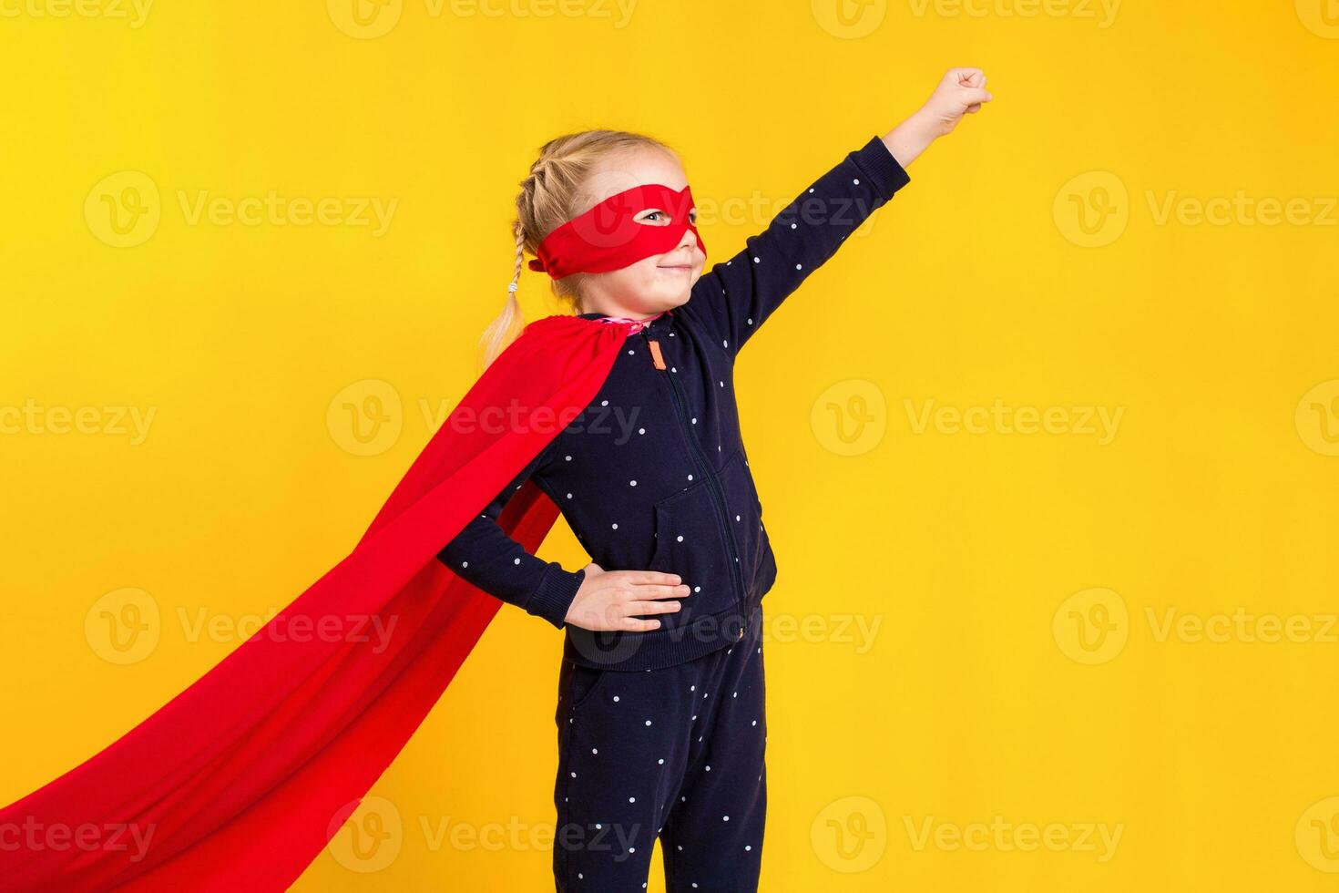 Superhero little girl in a red raincoat and a mask photo