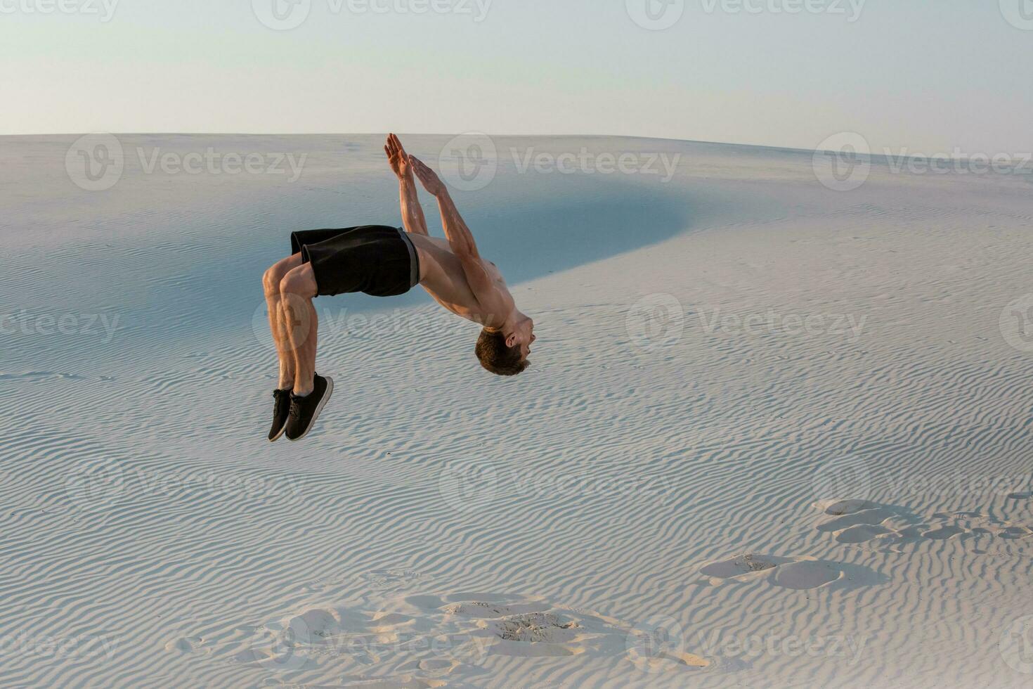 hombre estudiar parkour en su propio. acrobacia en el arena foto