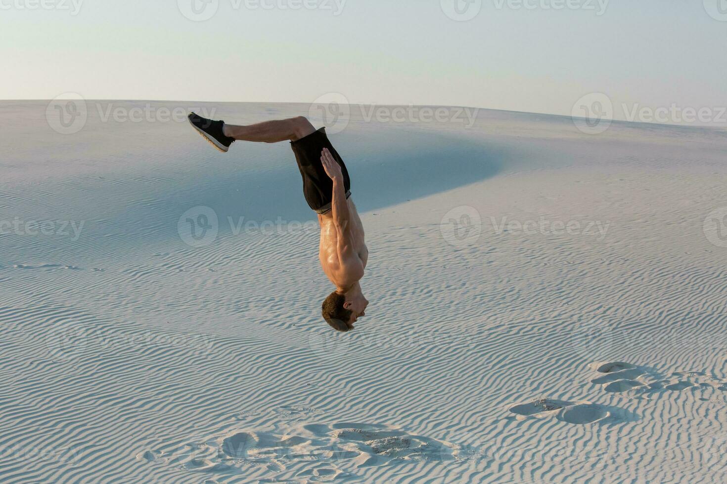 Man study parkour on their own. Acrobatics in the sand photo