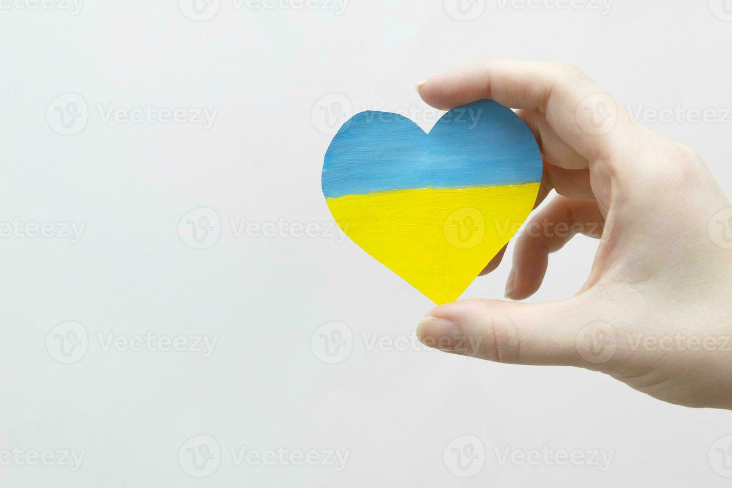 The concept of ending the war in Ukraine. heart in the colors of the flag of Ukraine in female hands. photo