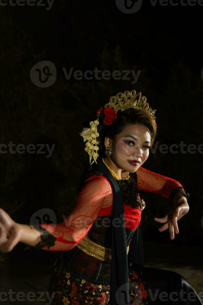 an Indonesian dancer posing with her beautiful and beautiful hands while wearing makeup at night photo